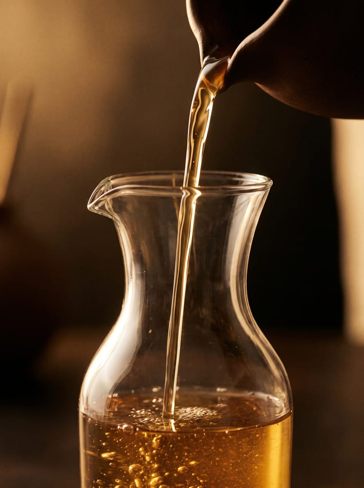 Un liquido ambrato versato in una caraffa di vetro